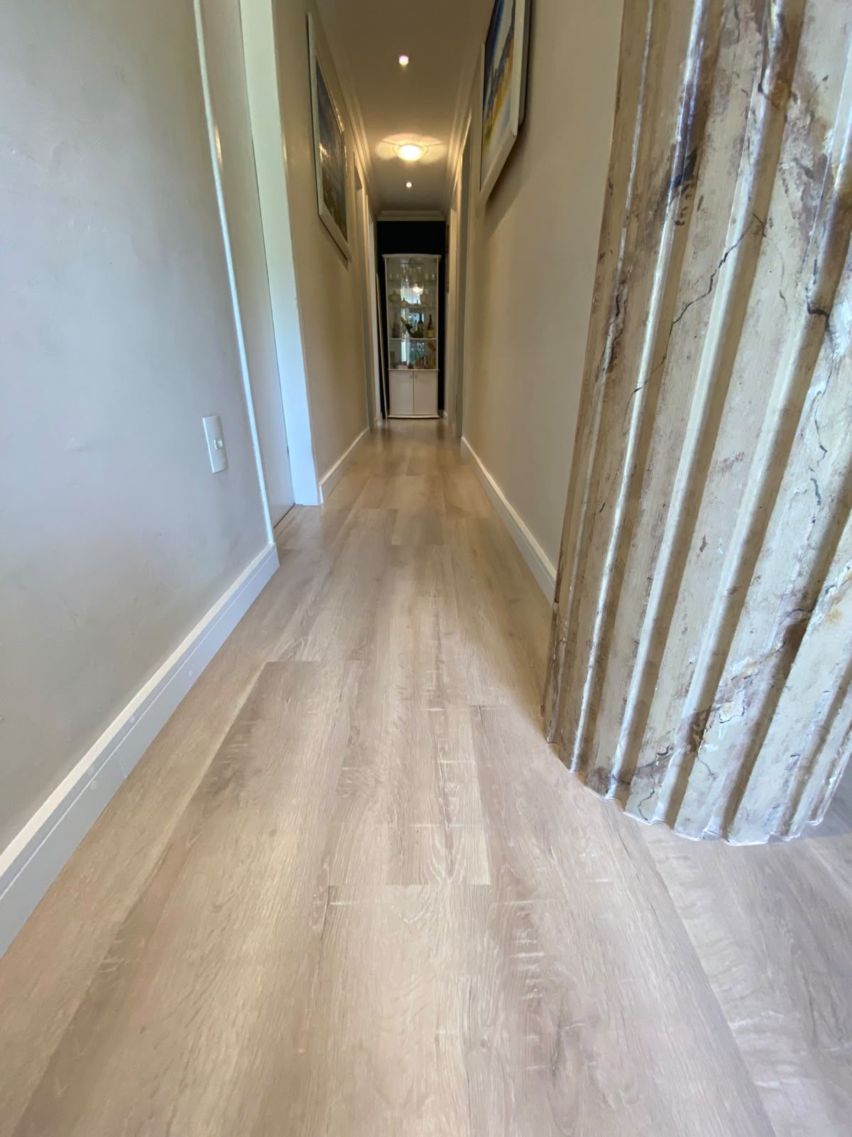 Hall de entrada com piso laminado e coluna decorativa