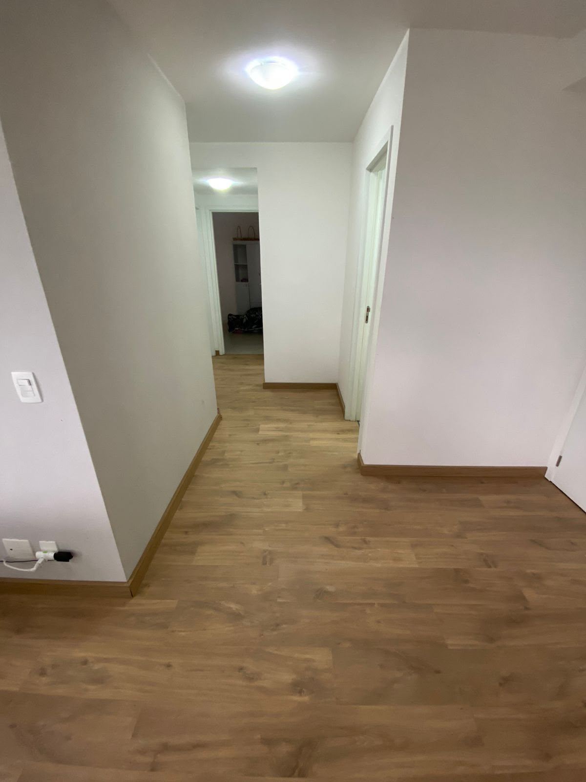 Corredor com piso laminado em tom escuro