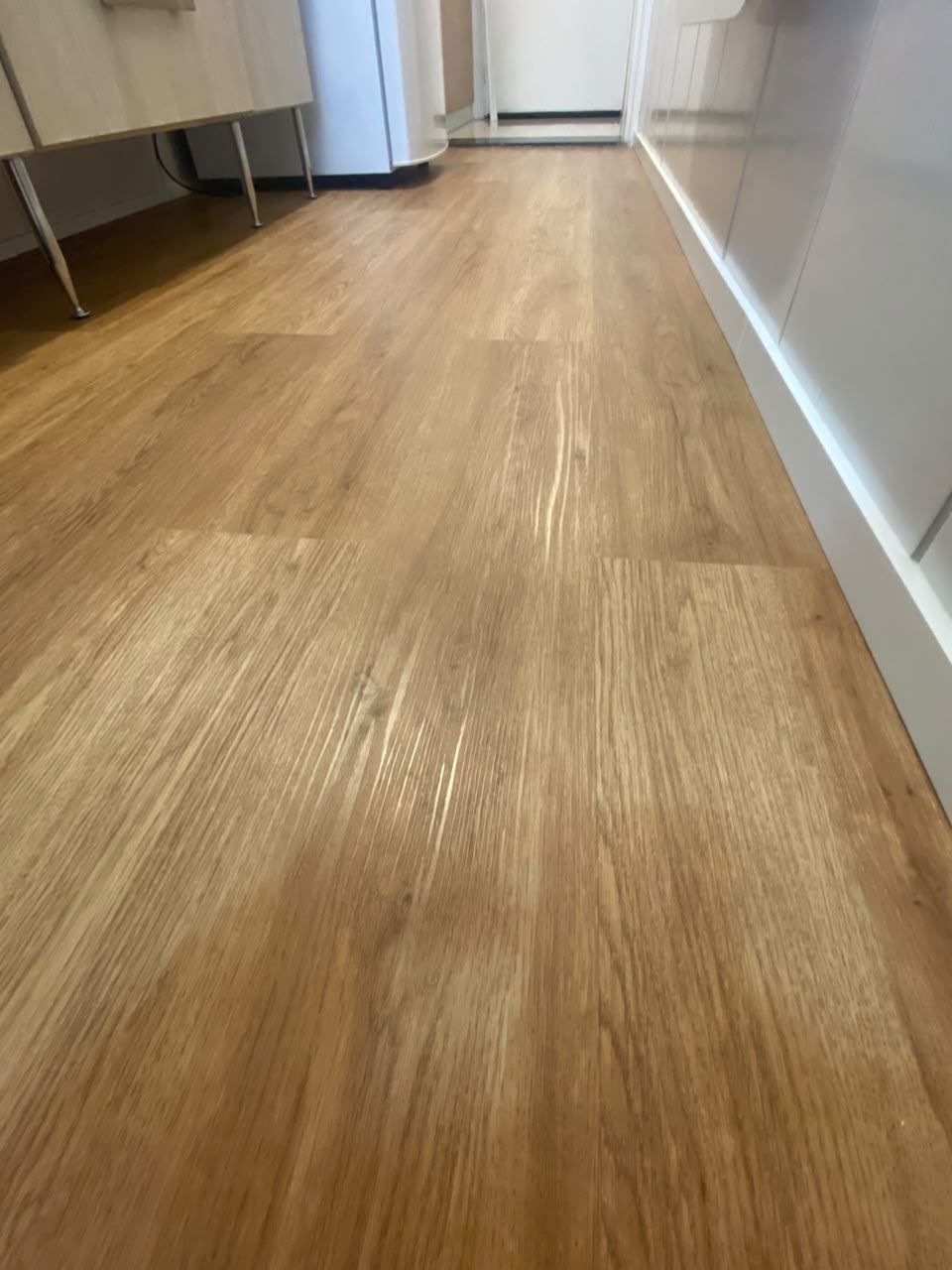 Corredor com piso vinílico e detalhe de rodapé