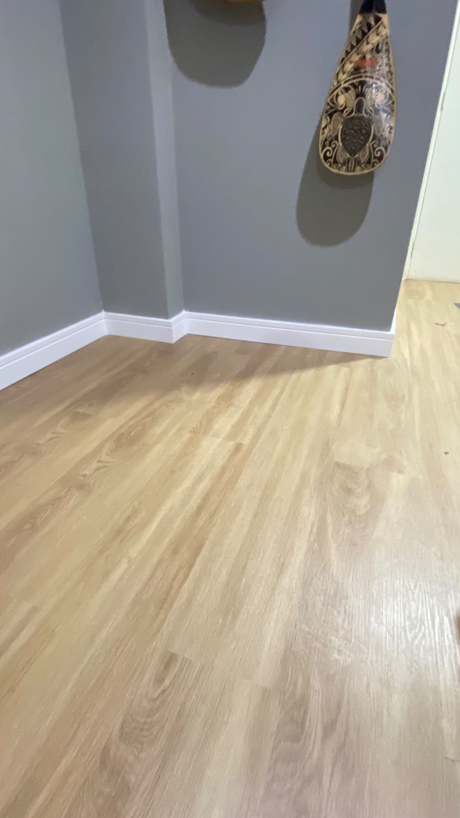 Detalhe de canto e rodapé com piso vinílico claro